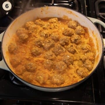 simmering german meatballs and sauerkraut in a dutch oven on the stove top.