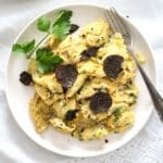 truffle eggs on a small white plate with fork and parsley.