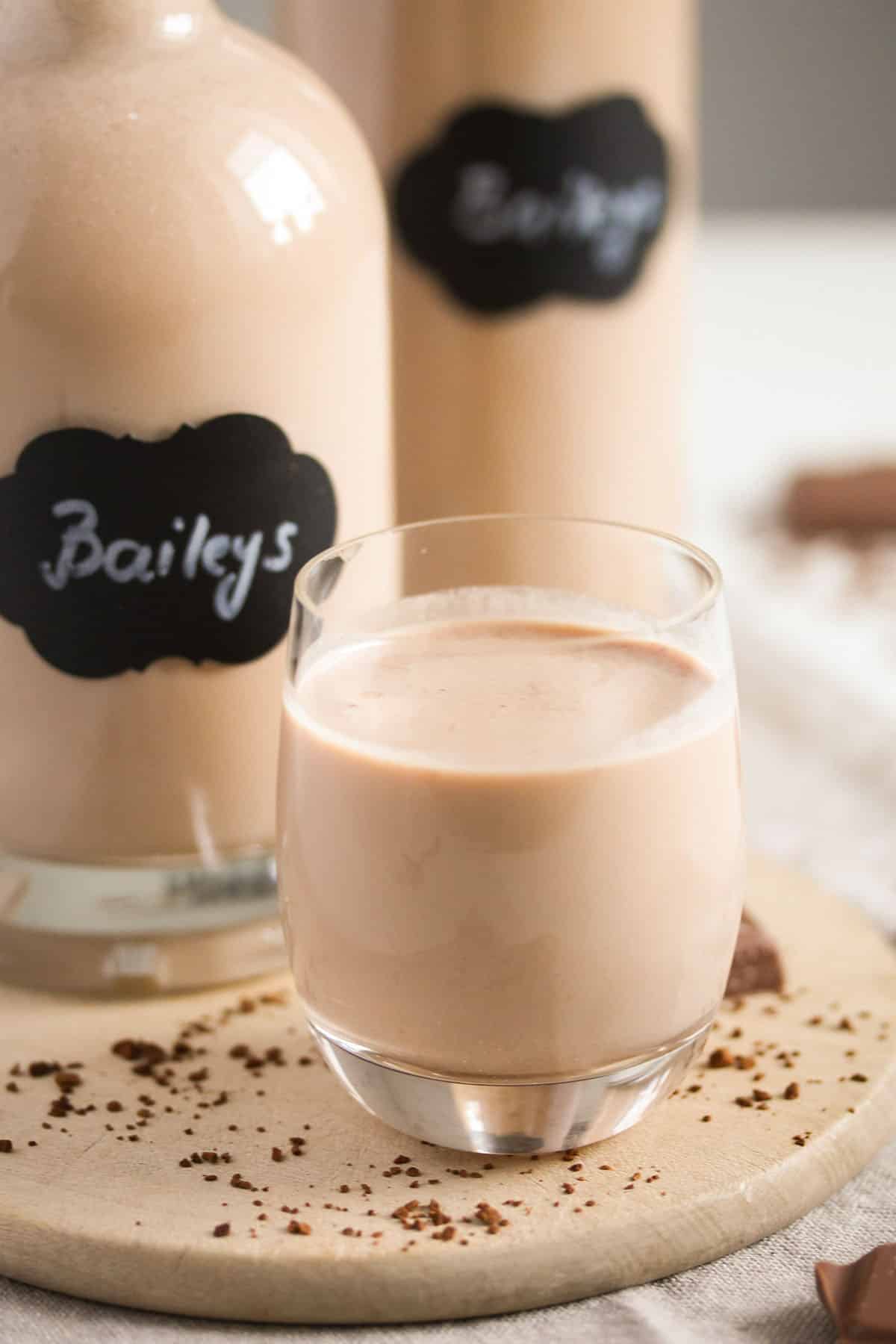 one small glass of homemade bailey's and two full bottles behind it.