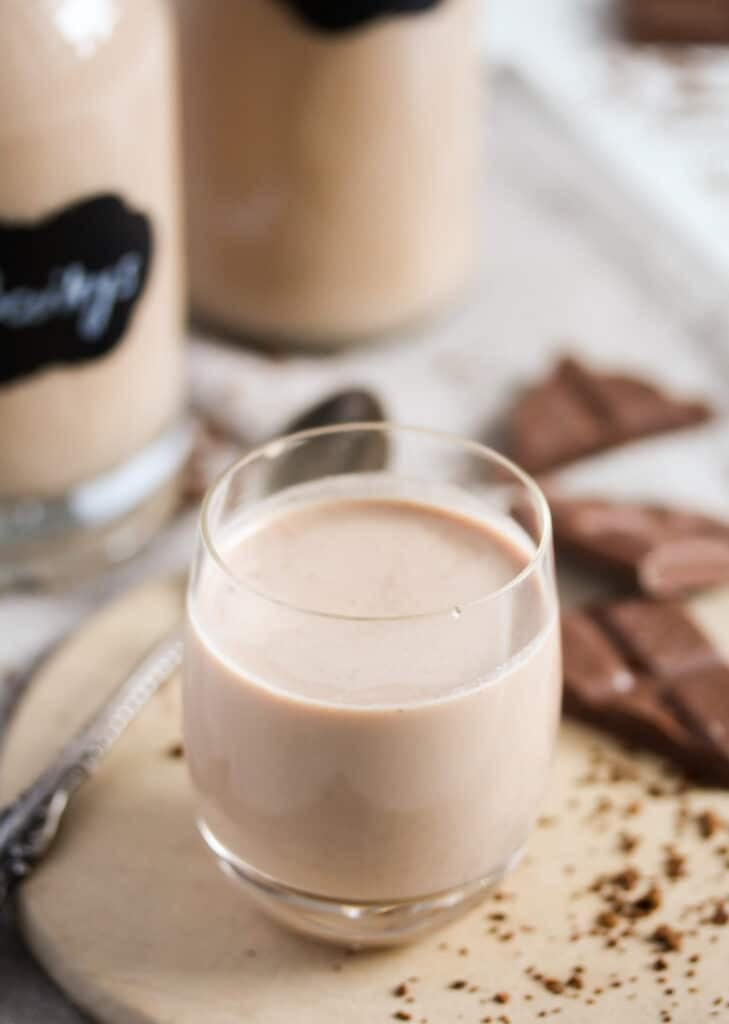 small glass with homemade creamy drink and chopped chocolate behind