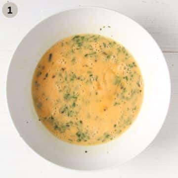 beaten eggs with parsley and cream in a bowl.