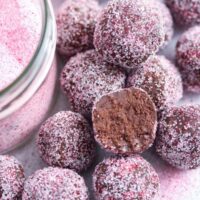 many chocolate champagne truffles coated with pink colored sugar.