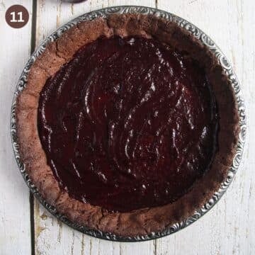 adding chocolate filling to a chocolate tart shell.