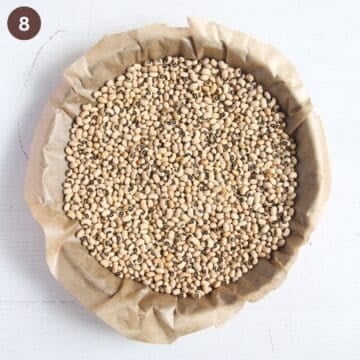 parchment paper and beans in a tart shell for blind baking.