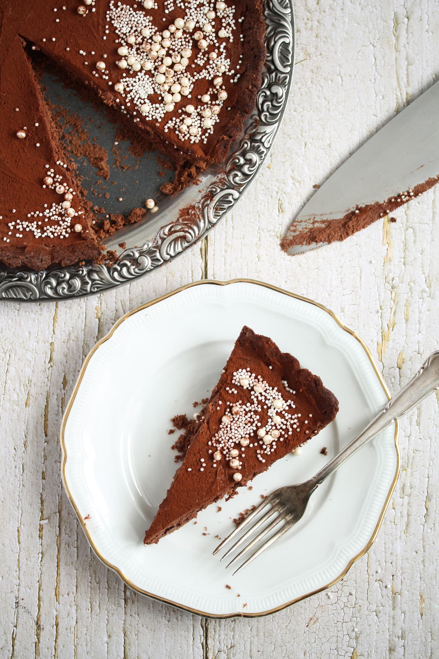 overhead picture of a chocolate tart on a platter and on a plate.
