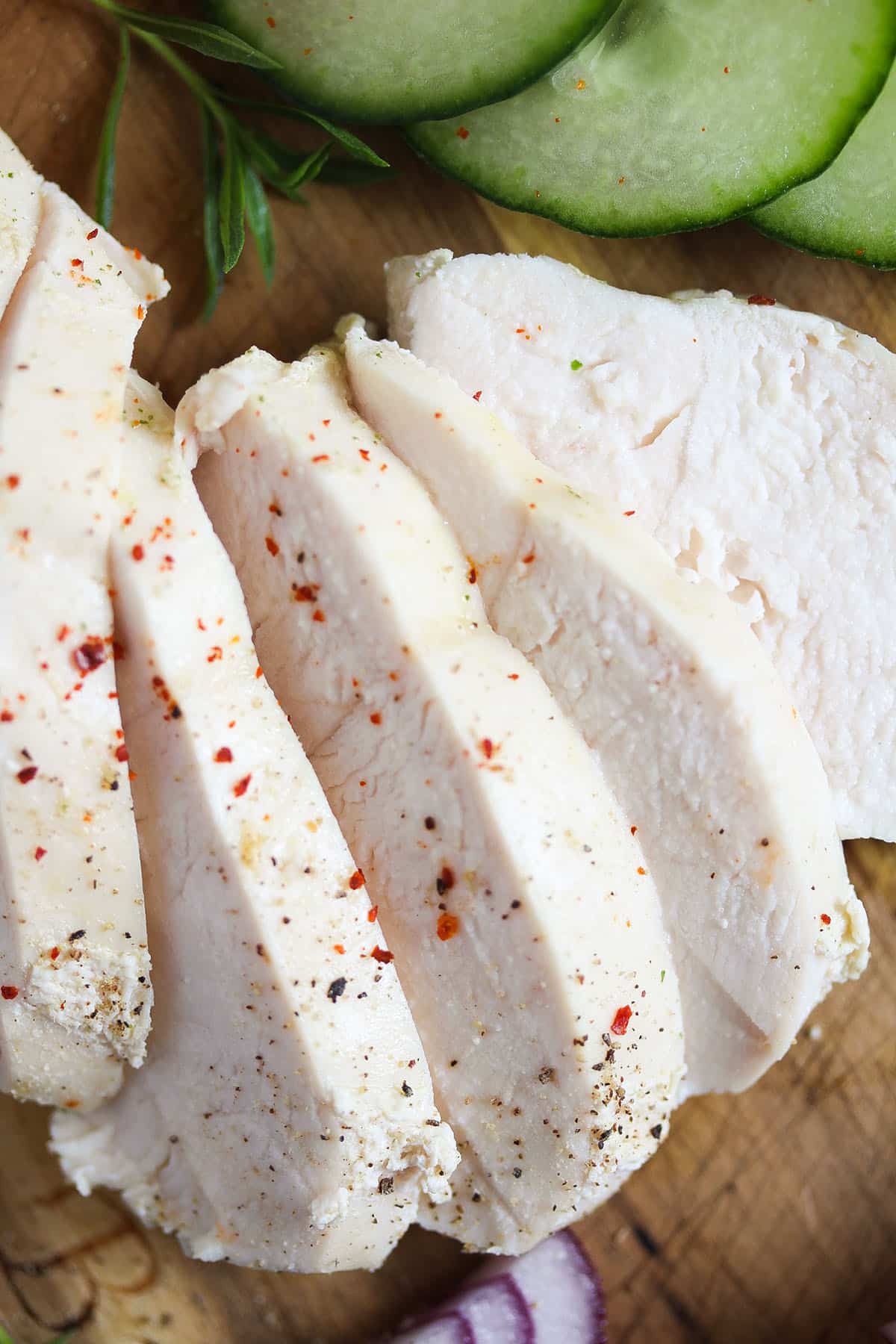 one sliced boiled chicken breast sprinkled with chili flakes.