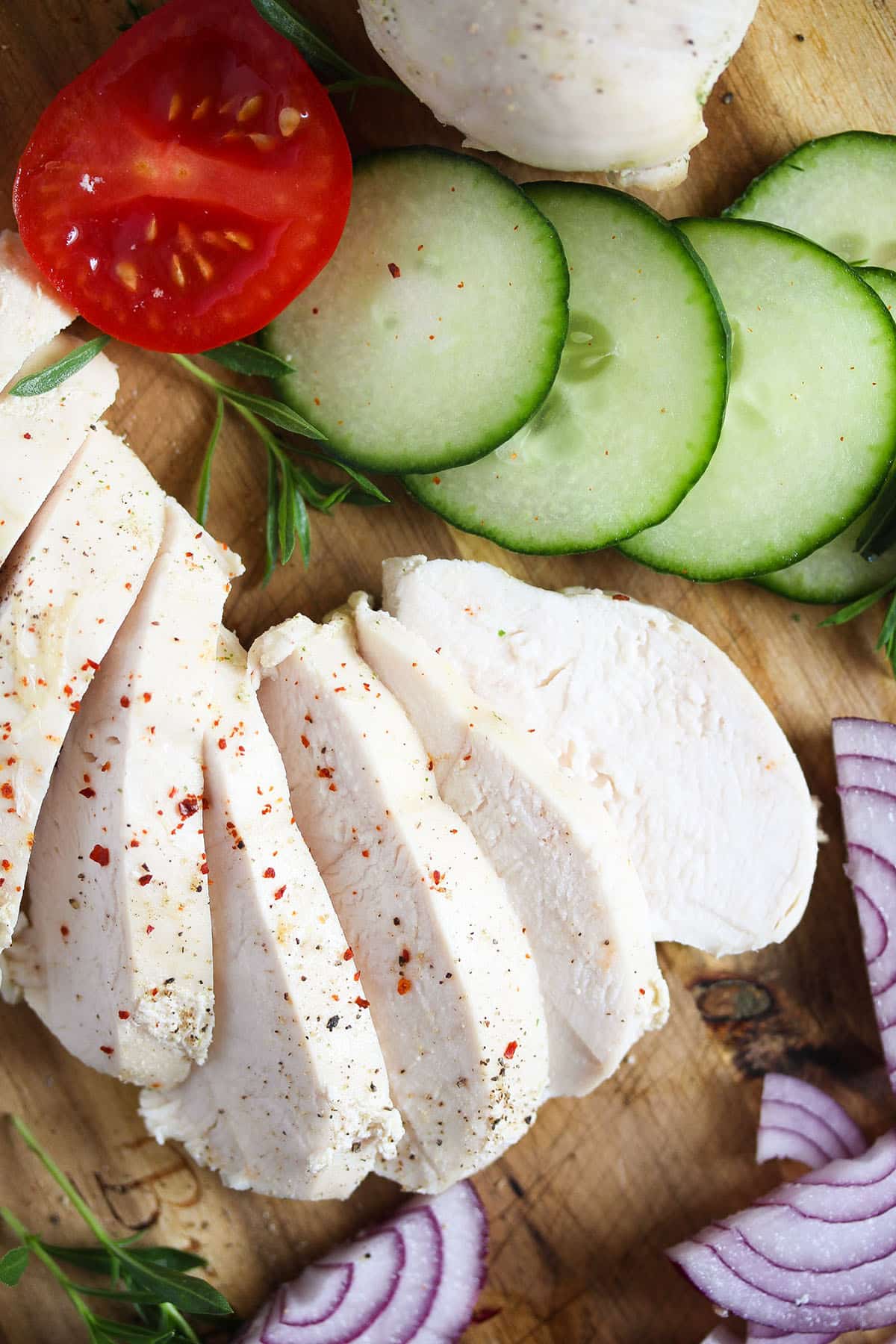 sliced chicken breast, tomatoes, cucumbers, and onions.