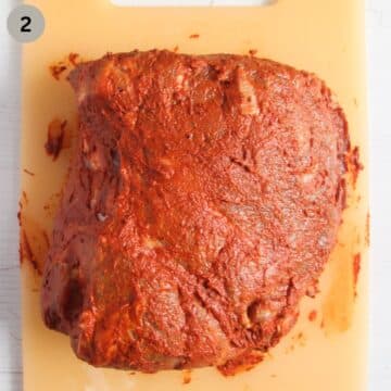pork rubbed with a seasoning paste on a cutting board.