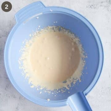 beaten egg yolks and sugar for making cake batter in a blue bowl.