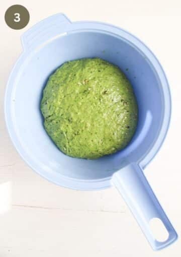 green dough for bread in a blue bowl.