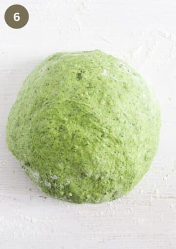 a ball on green bread dough on the table.