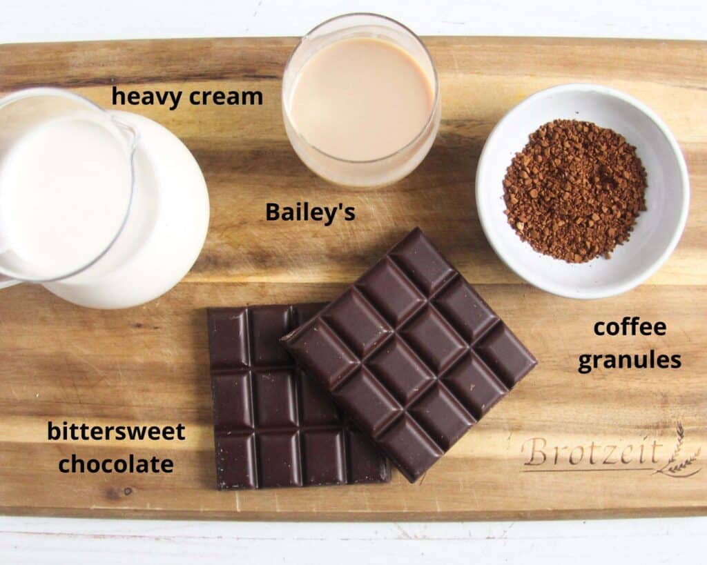 cream, baileys, coffee granules, chocolate on a chopping board.