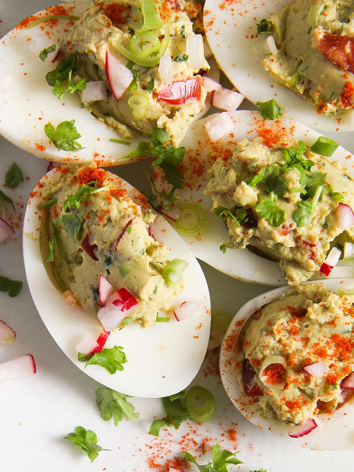 close up of spicy mexican stuffed eggs filled with avocado and tomatoes.