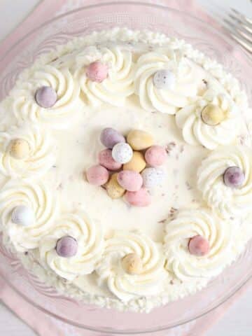 mini egg cheesecake on a pink cloth seen from above.