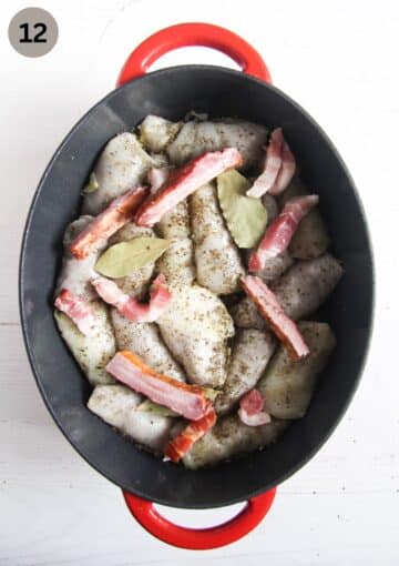 arranging sarmale and pork pieces in a dutch oven.