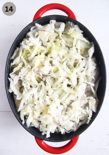 covering uncooked sarmale with a layer of chopped cabbage in a dutch oven.