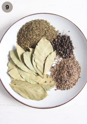 bay leaves, savory, peppercorns on a small plate.