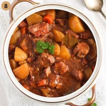 one ot full of lamb casserole with potatoes and carrots.