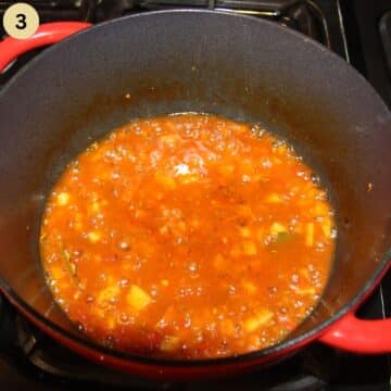 simmering tomato sauce to make fish stew in a pot.