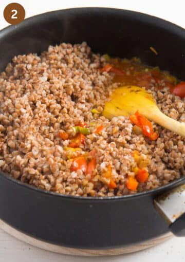 stirring cooked buckwheat in a saucepan.
