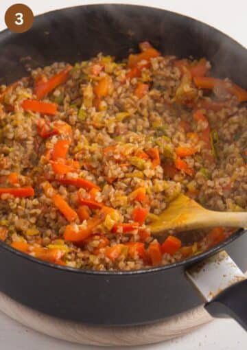mixing vegetables into buckwheat in a saucepan.