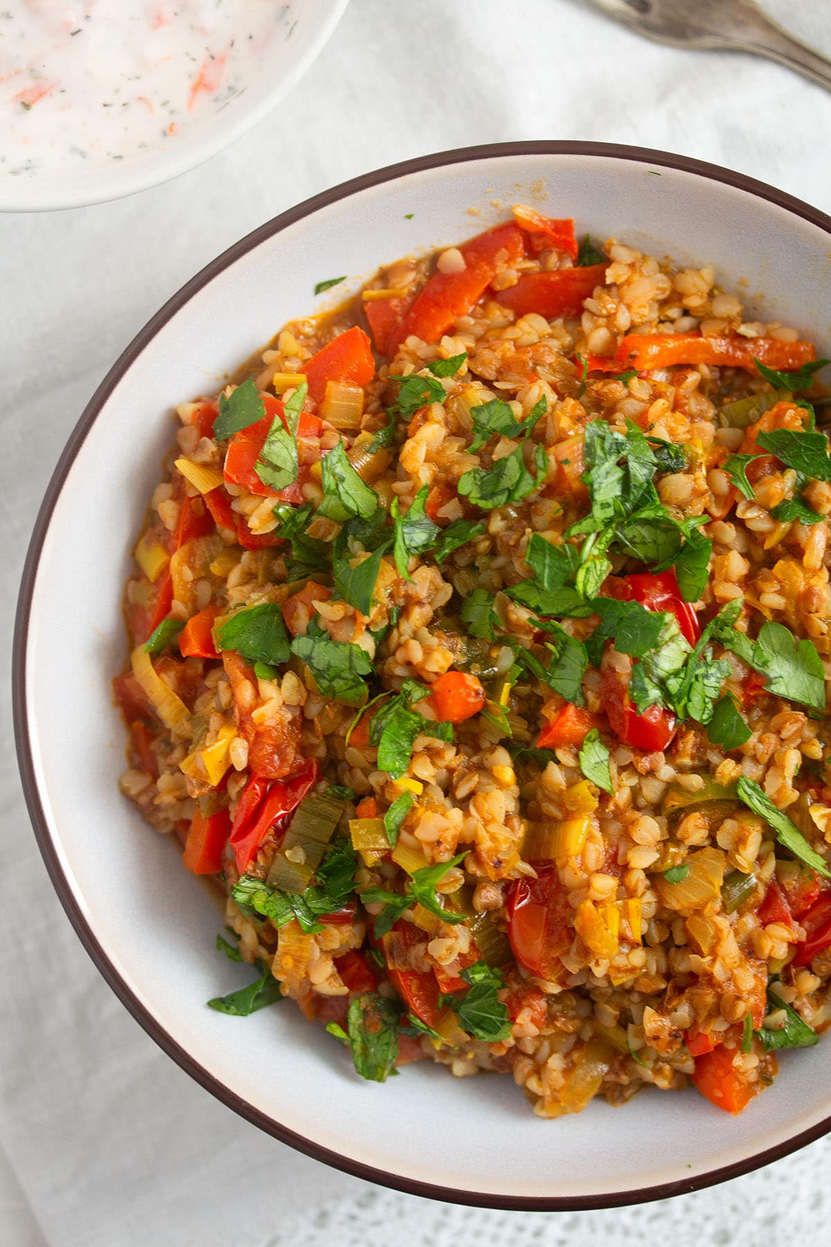 buckwheat with vegetables and herbs in a bowl on the table.
