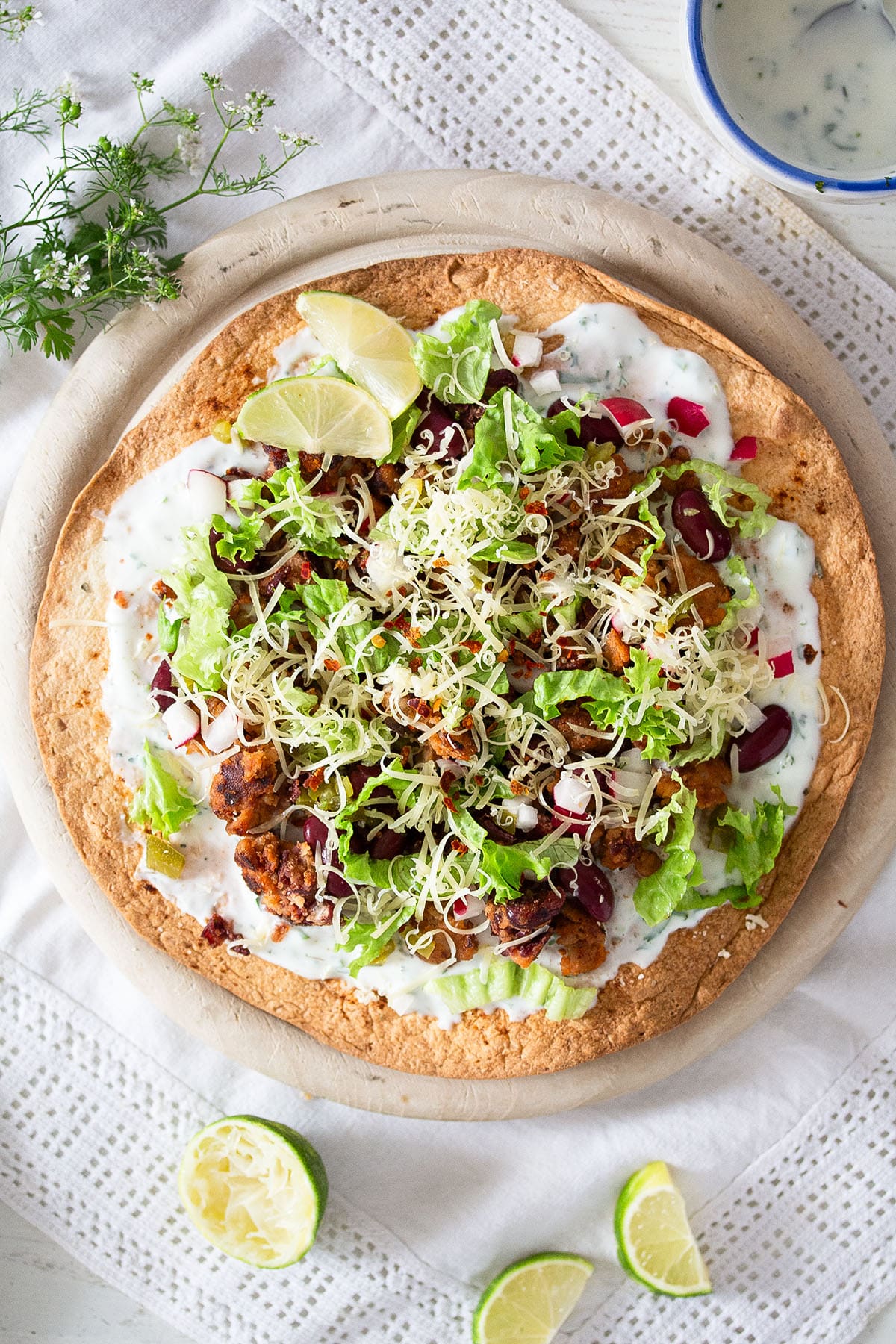 tostada with chorizo, cheese, kidney beans, limes and cheese.