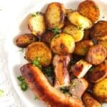 plate with potatoes and bratwurst close up.