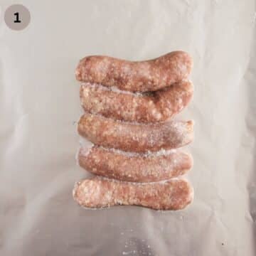 five frozen sausages on aluminum foil lined baking sheeet.