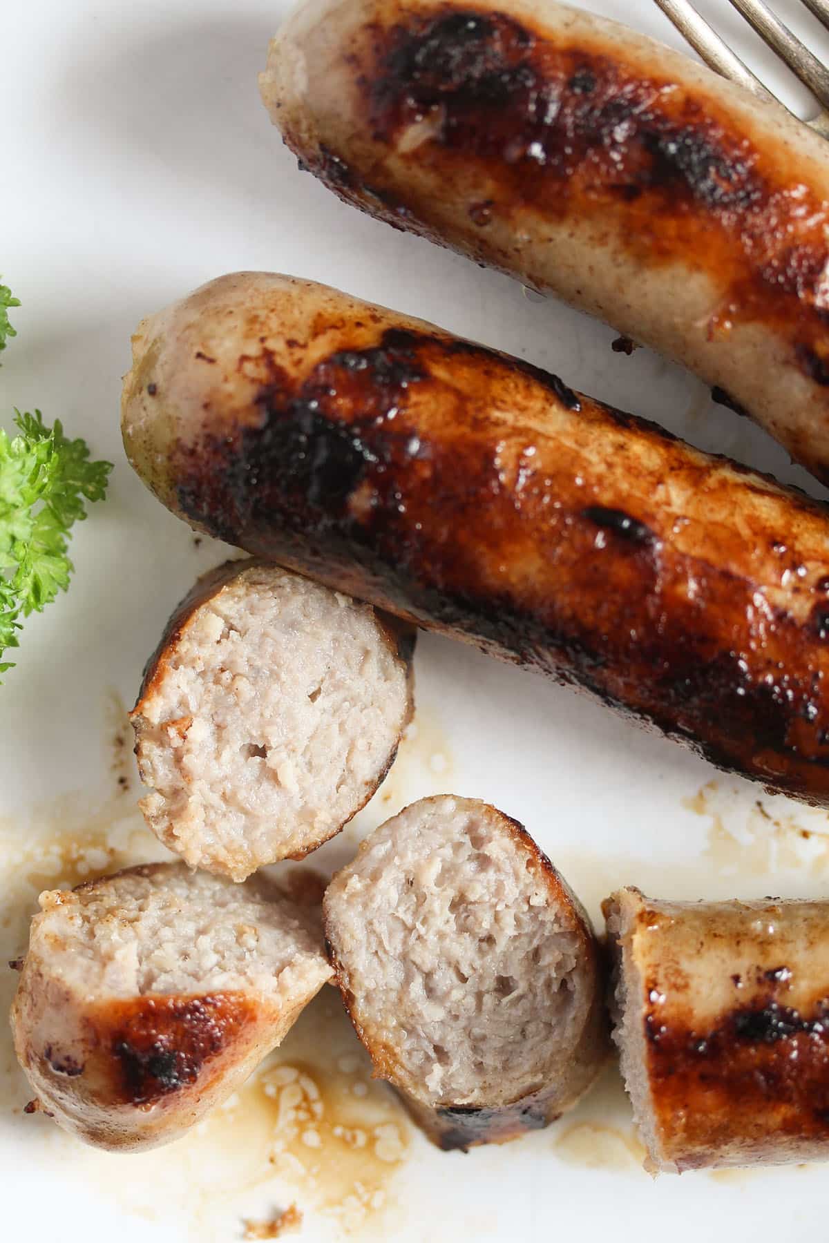 sausages cooked from frozen, one of them sliced.