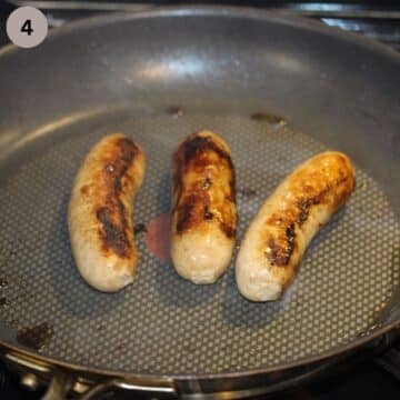 three browned brats in a nonstick pan.