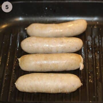 four parboiled sausages in a grill pan.