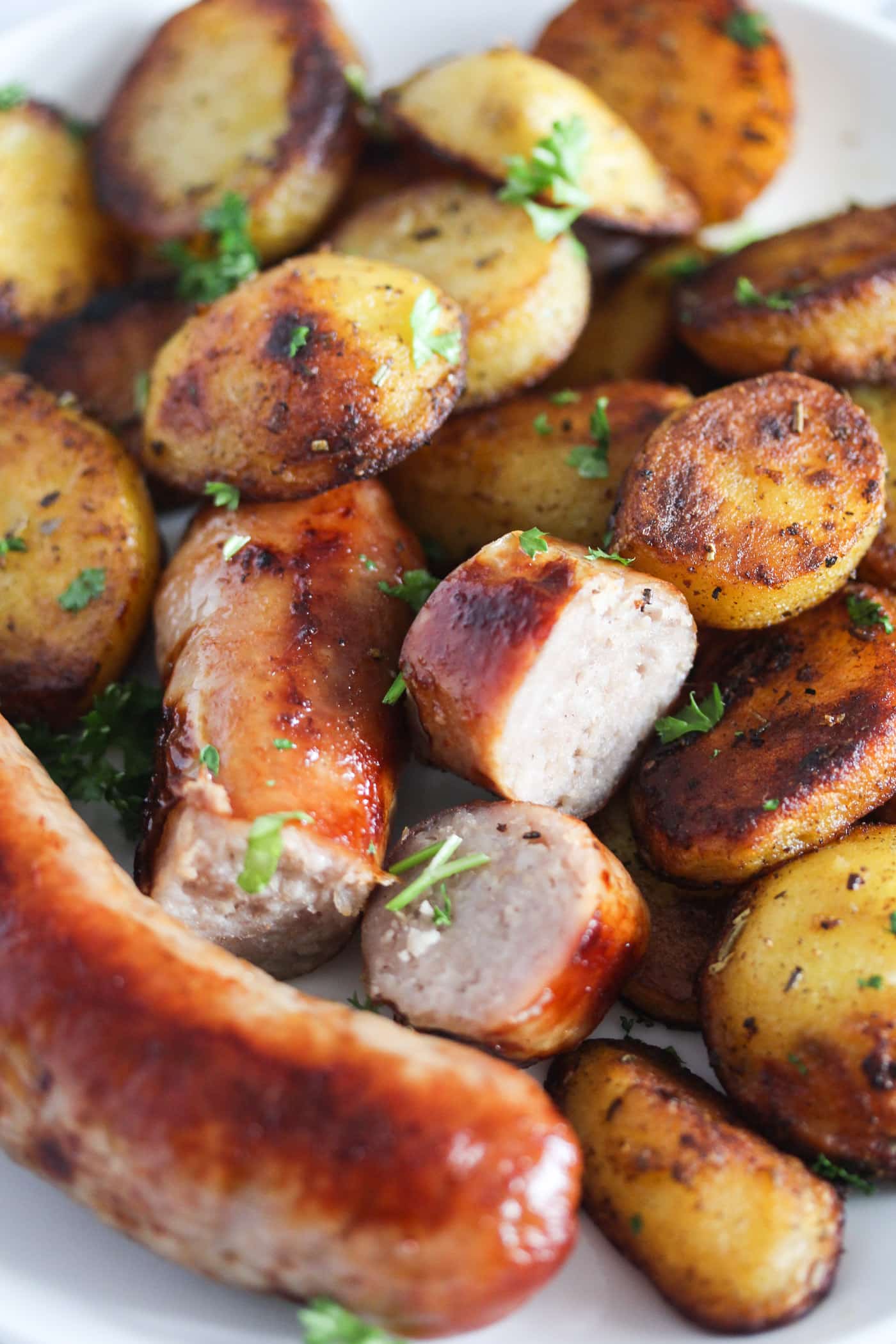 potatoes and brats on a plate close up.