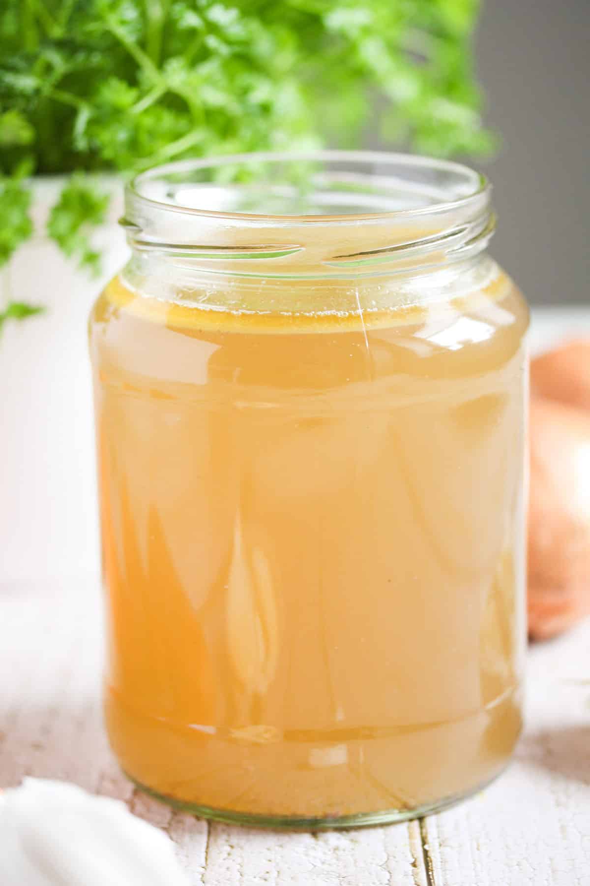 one large jar full of lamb bone stock and parsley behind it.