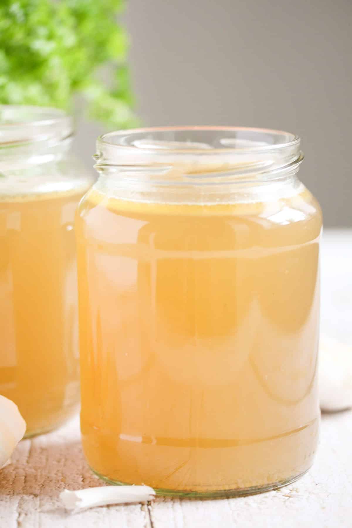 two jars containing lamb stock on the table.