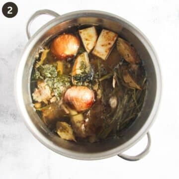 ingredients for making lamb stock in a large pot after cooking.