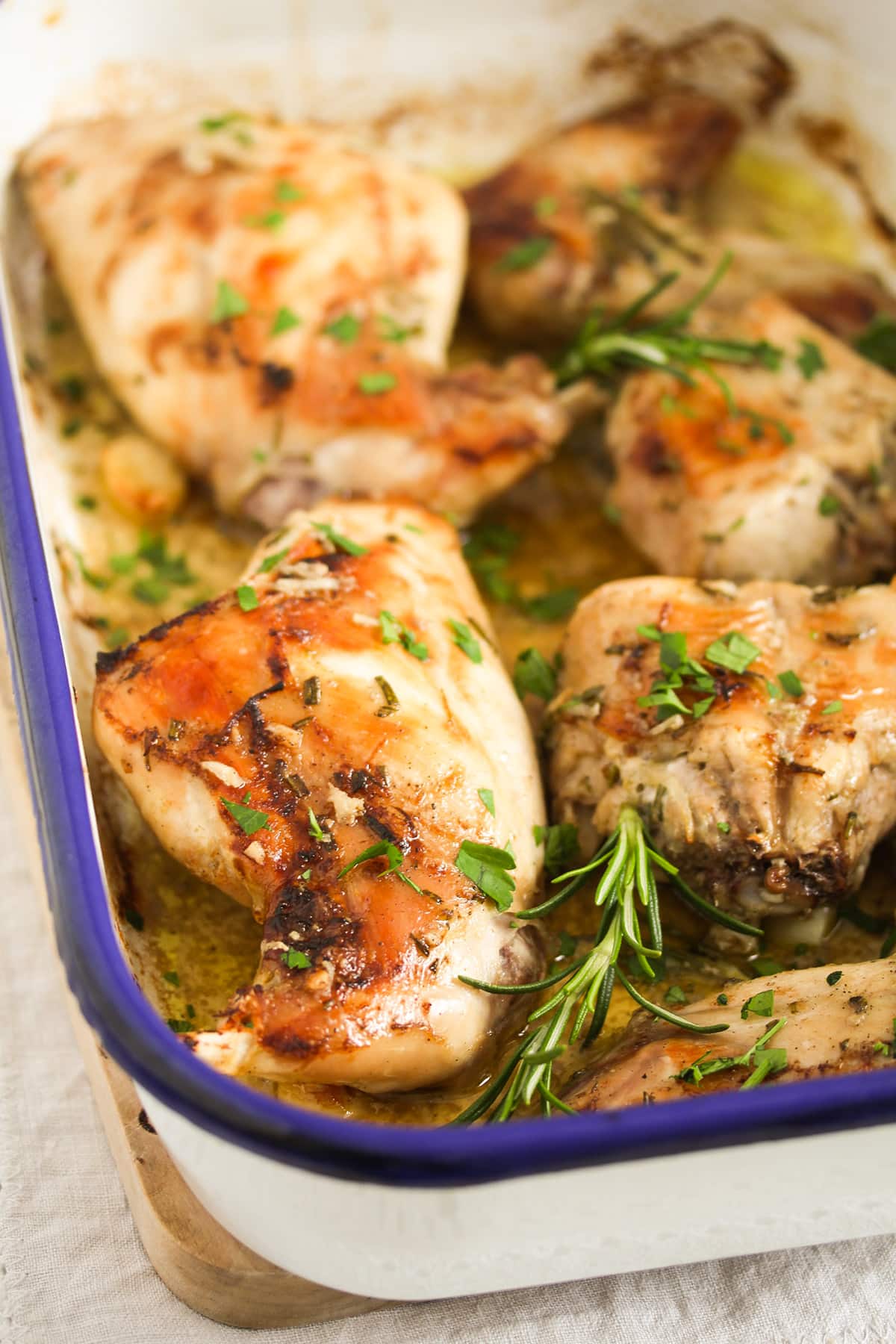 golden roasted rabbit pieces in a roasting tin.