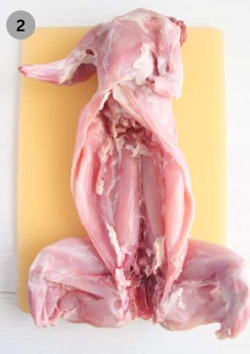one cleaned rabbit on a cuttting board.