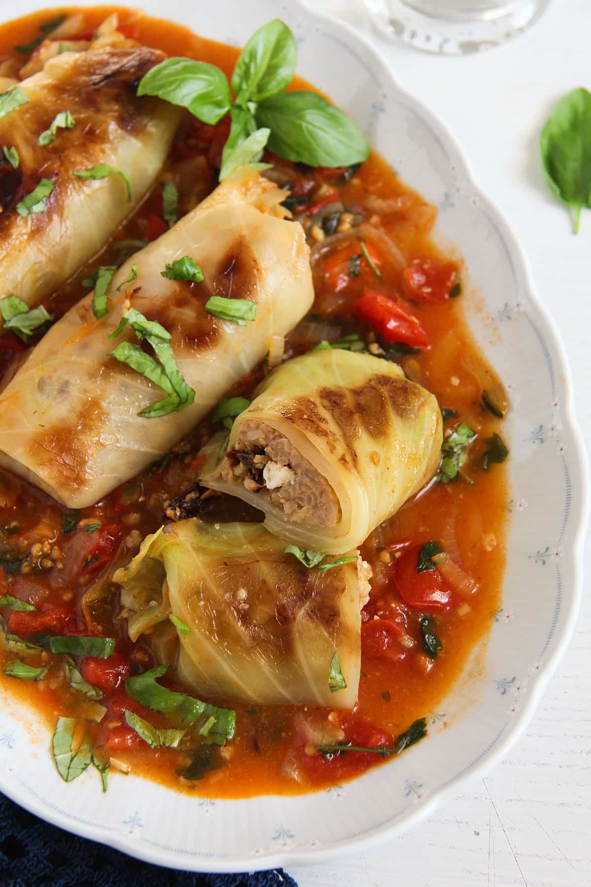 vegetarian cabbage rolls, one cut showing the rice and feta filling.