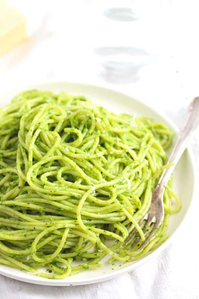 ramsons spaghetti with a fork on a white plate.