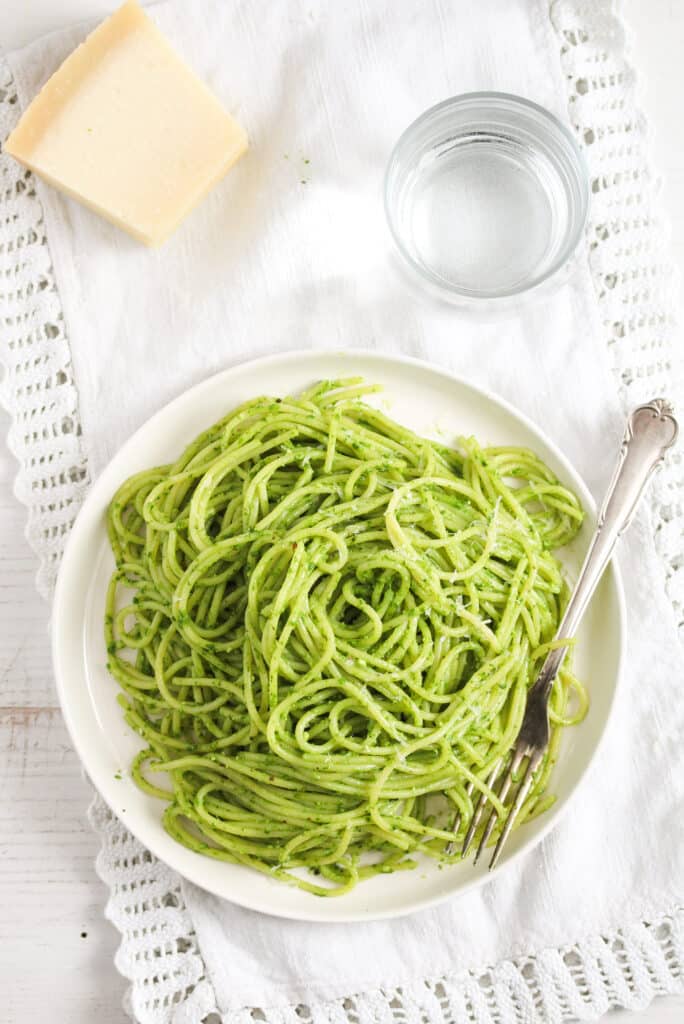 overhead shot of wild garlic pasta and piece of parmesan.