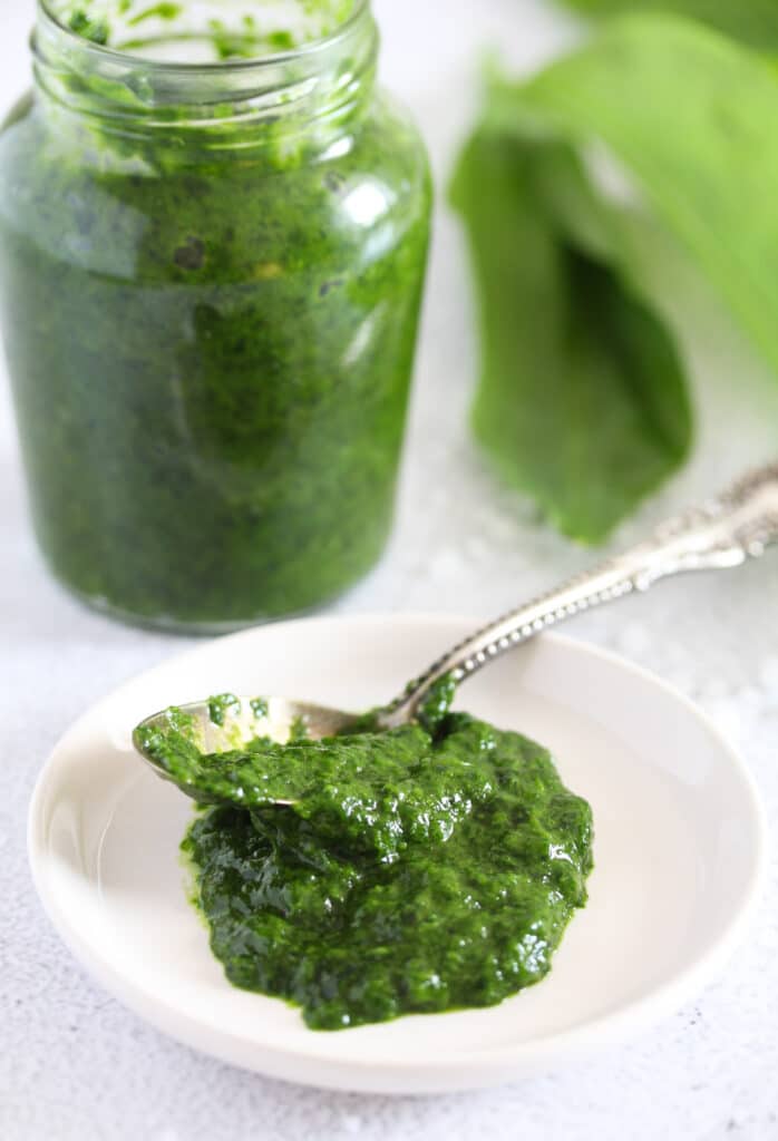 jar of herb paste and some on a small plate with a teaspoon in it.