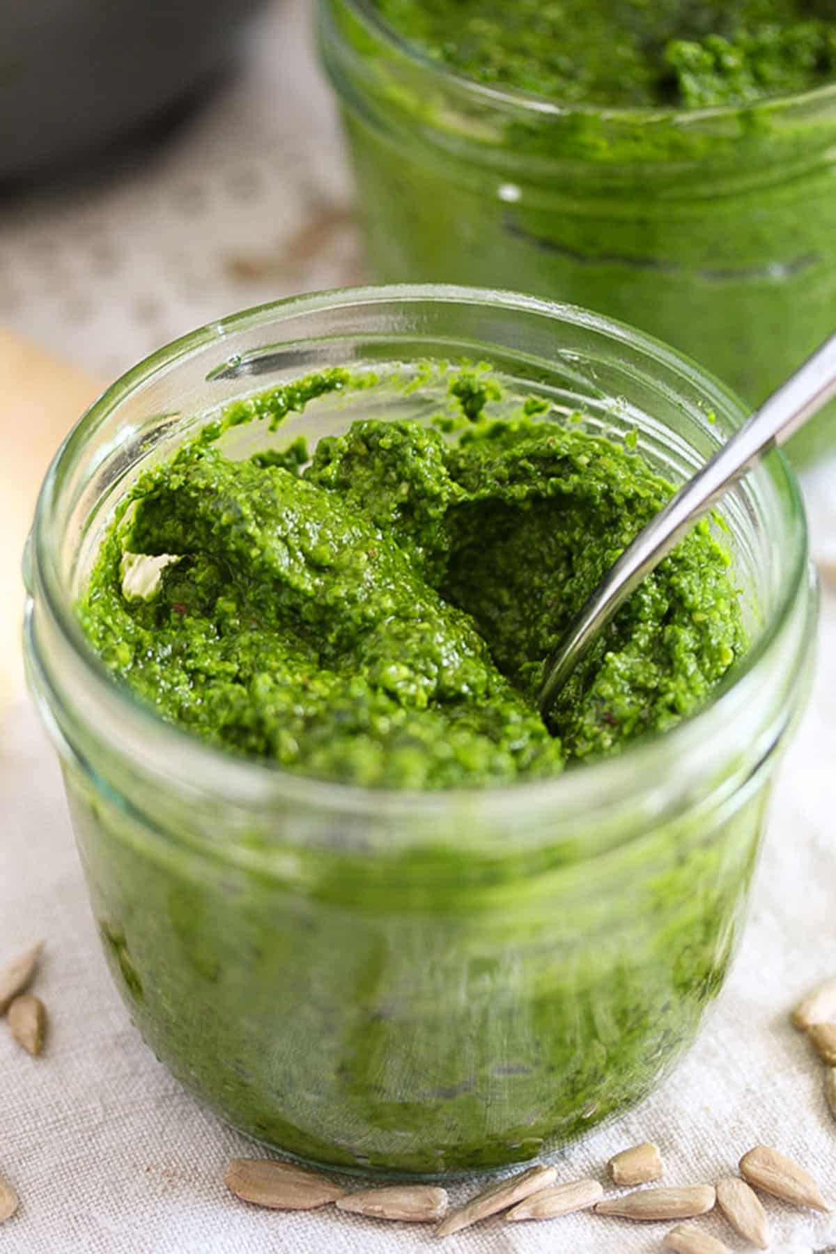 wild garlic pesto in a jar with a spoon in it.