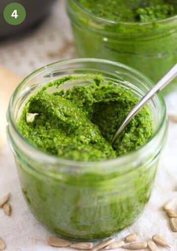 one small jar with wild garlic pesto with a spoon in it.