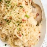 a large plate with bavarian sauerkraut and a spoon.