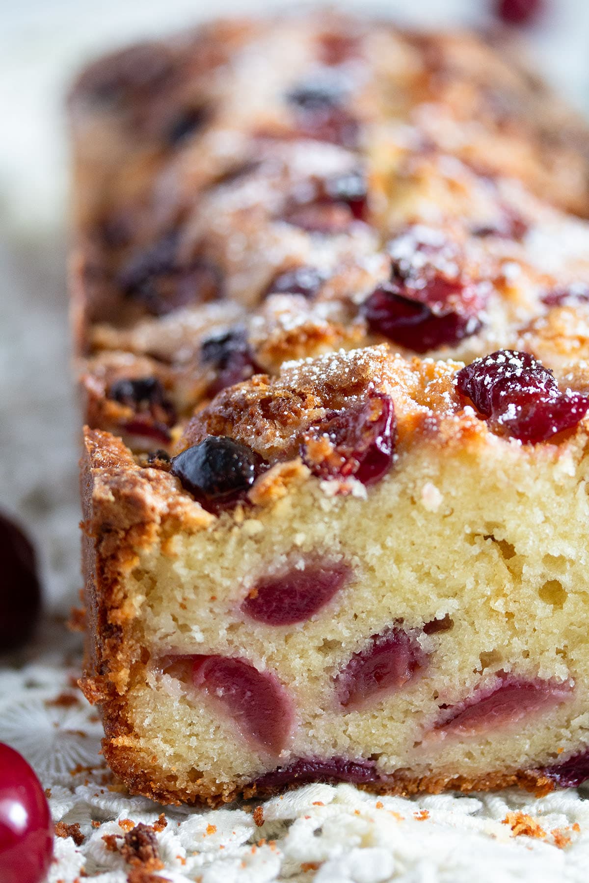 loaf of cherry cake showing the cherries and the moist crumb inside. 