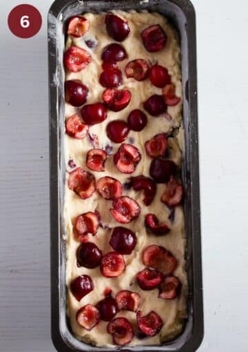 unbaked cake batter sprinkled with fresh cherries.