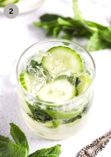gin, cucumbers, mint and ice in a glass.
