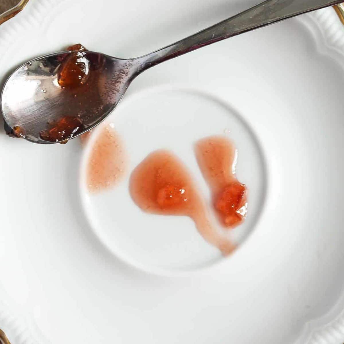 checking the consistency of jam using the frozen plate test.