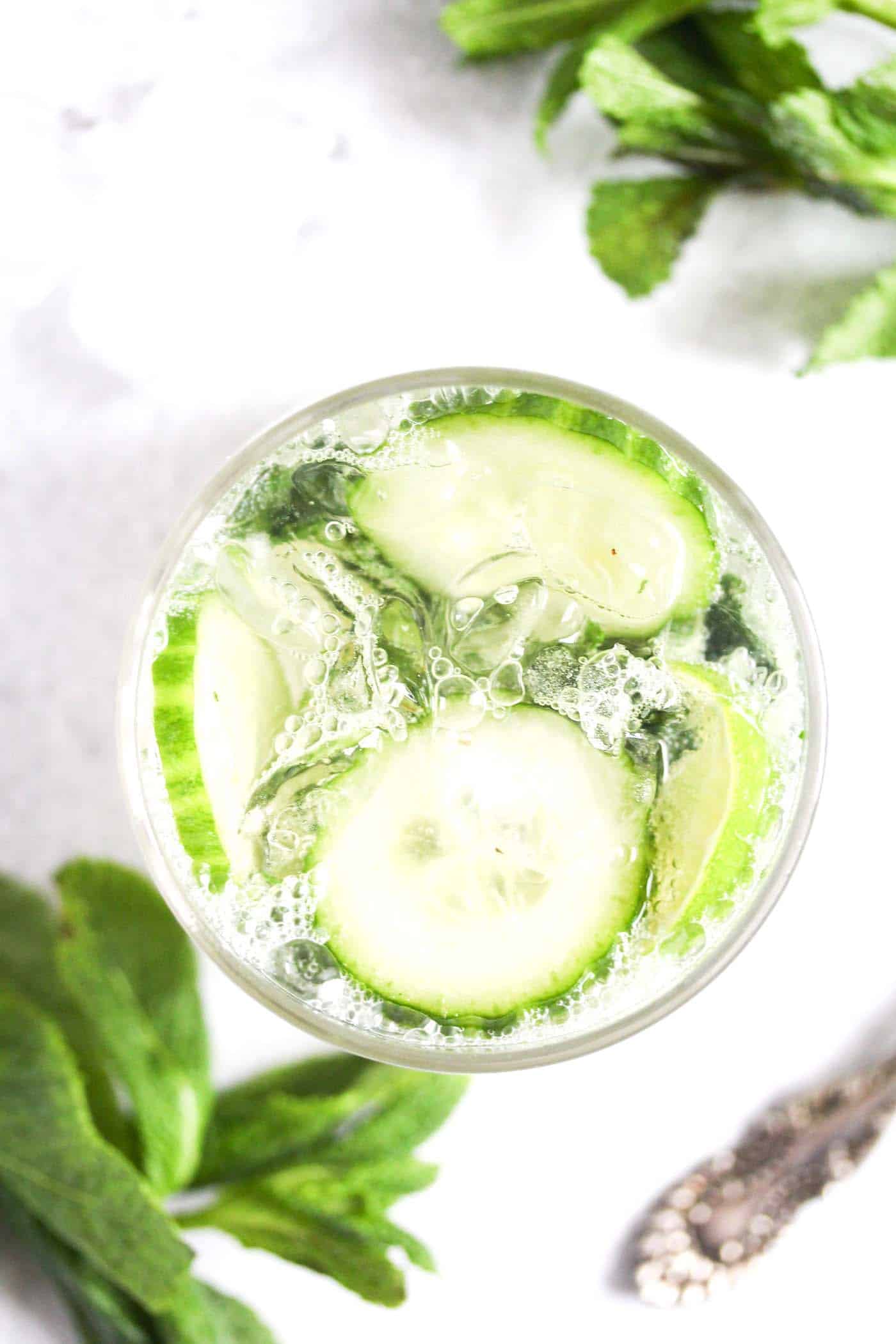 overhead view of mojito with gin, limes and mint in a glass.